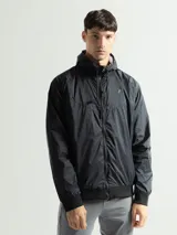 Campera de nylon impermeable color negro, con cierre frontal y capucha, ideal para actividades al aire libre.