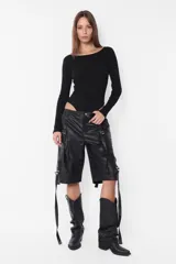 Campera puffer negra de cuero sintético, con cuello alto, cierre frontal con cremallera y bolsillos laterales.