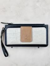 Billetera de cuero con cierre superior y correa de muñeca. Presenta un bolsillo frontal con textura símil cocodrilo y un aplique con el logo de la marca.