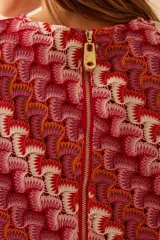 Top tejido de poliéster y viscosa con estampado abstracto en tonos rojo, naranja y blanco. Tiene mangas cortas abullonadas y cuello redondo.