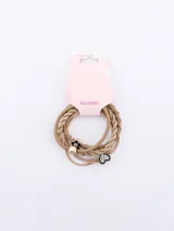 Set de tres gomitas para el pelo color beige, una con forma de corazón con strass, otra con forma de flor y otra con detalle de cubo dorado.