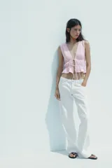 Top amarillo con estampado de cuadros vichy blancos, escote en pico, sin mangas, con detalle de elásticos en la cintura y cierre frontal con lazadas.