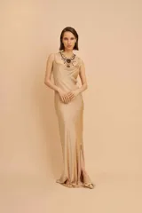 Vestido largo de seda color dorado, con escote en forma de buche y breteles finos.