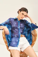 Camisa de seda estampada con diseño batik en tonos azules y blancos, corte amplio y mangas al codo.