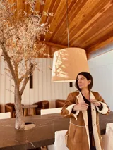 Abrigo gamulan color marrón con interior de piel sintética color crema, corte holgado, largo a la rodilla y tajos laterales.