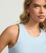 Top cropped sin mangas, color marrón oscuro, de corte ajustado al cuerpo y cuello redondo. Presenta textura acanalada.