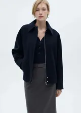 Falda midi gris con raya diplomática, diseño lápiz, cinturón desmontable y abertura en el bajo.