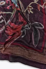 Pañuelo rectangular color borgoña con estampado floral en tonos rojos, verdes y amarillos. Presenta un borde decorativo con motivos geométricos.