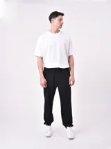 Pantalón de jogging negro con cintura elástica y cordón ajustable. Corte holgado con puños elásticos en los tobillos.