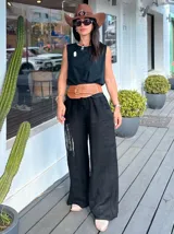 Pantalón palazo de lino negro, suelto y liviano, con cintura elástica y cordón ajustable.