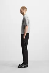 Pantalón color arena de corte recto, confeccionado en tejido elástico. Cuenta con cintura elástica ajustable con cordón, bolsillos laterales y bolsillos de vivo en la parte trasera.