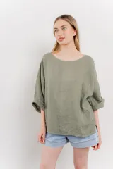 Blusa verde oliva de lino, de corte holgado, mangas 3/4 y cuello redondo.