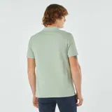 Chomba de piqué de algodón color verde claro con estampado de pequeñas figuras geométricas en negro. Tiene cuello clásico con botones y mangas cortas.
