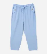 Pantalón de crepé celeste, modelo zanahoria, con elástico y lazo en la cintura. Presenta bolsillos traseros simples y bolsillos delanteros con solapas y botones metalizados.