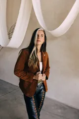Blazer marrón de gamuza con cuello solapa, cierre con un botón y corte clásico.