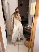 Túnica larga color beige con estampado floral en tonos grises, con cuello mao y mangas 3/4.