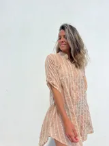 Vestido camisero color beige con bordado vertical en color blanco, de corte recto, cuello mao y mangas cortas con trabilla.