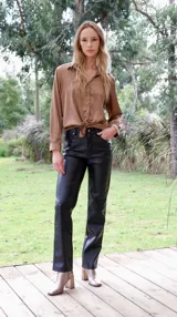 Pantalón de cuerina color negro, corte recto y tiro alto.