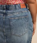 Pollera corta de jean de lavado diferenciado, con trabillas en la cintura, cierre delantero y bajo con corte a hilo.