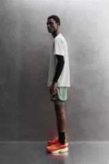 Camiseta de entrenamiento color marrón, de corte regular fit, confeccionada en tejido técnico ligero y elástico con estructura. Tiene cuello redondo, mangas cortas, costuras planas y logo estampado.