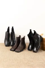 Botas Chelsea de cuero color marrón con elástico lateral negro, puntera metálica cuadrada y suela track.