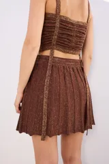 Minifalda tejida color marrón con lurex dorado, corte acampanado y pretina elástica.