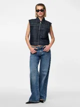 Chaleco de denim azul oscuro con cuello con solapas, cierre frontal con cremallera metálica y dos bolsillos de parche en el pecho.