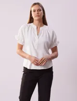 Blusa blanca de gasa marca Floral & Ivy, con cuello a la base y escote en V. Mangas cortas con elástico fruncido.