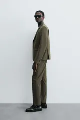 Pantalón de vestir azul marino, de corte slim fit, con bolsillos laterales y traseros de vivo con botón. Se ajusta a la cintura con cierre frontal con cremallera y botón.