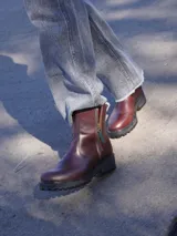 Botas de cuero color marrón con suela de goma negra y cierre lateral con cremallera.