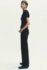 Pantalón de jean azul oscuro, de tiro alto, corte wide leg y largo hasta el tobillo.