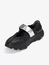 Zapato tipo bailarina color negro, con elástico en el borde superior y hebilla plateada.