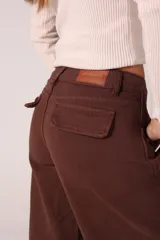 Pantalón jean marrón de corte ancho con costuras marcadas y bolsillos laterales.