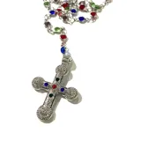 Collar tipo rosario con cadena plateada y cuentas de cristal de colores. Dije de cruz plateada con incrustaciones de cristales de colores.