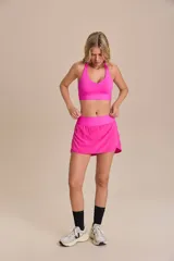 Pollera deportiva color verde lima, con short interno y bolsillo en la cintura.