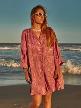 Vestido camisero corto de lino con estampado floral en tonos rosados y marrones.