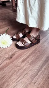 Sandalias marrones de cuero con plataforma forrada en cuero y hebillas ajustables.