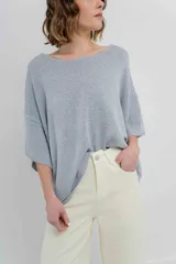 Sweater oversize de tejido liviano con textura semi traslúcida, mangas amplias estilo murciélago, escote redondo y terminaciones suaves.