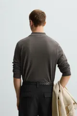 Polo azul marino de punto ligero tejido en hilatura con mezcla de seda y algodón. Cuello solapa con cierre frontal de botonadura, manga larga y acabados en rib.