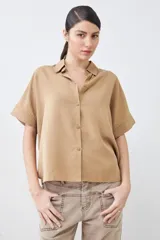 Camisa color pistacho de lyocell con cuello clásico, cierre frontal con botones y mangas cortas.