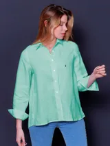 Camisa de lino color lila, de corte clásico, con cuello camisero y mangas largas con puños abotonados.