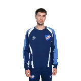 Buzo azul marino de algodón con recortes en blanco y celeste en mangas y hombros. Logo de Umbro bordado en blanco y escudo del Club Nacional de Football estampado en el pecho.