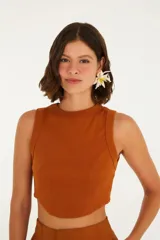 Top color beige, corte crop, con escote redondo y tirantes anchos.