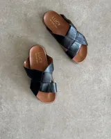 Sandalias bajas de cuero negro con tiras anchas cruzadas y plantilla anatómica color camel.