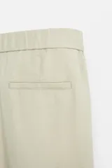 Pantalón negro regular fit confeccionado en tejido de lino. Cintura ajustable con cordón interior, bolsillos frontales y detalle de bolsillos traseros de vivo.
