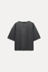 Top gris oscuro de tejido de punto canalé con cuello redondo y mangas cortas amplias.