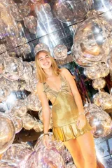 Vestido corto de lentejuelas color verde oliva, con escote en V, breteles finos cruzados en la espalda, cut-outs laterales y volado en el ruedo.