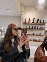 Gorra marrón de cuero con visera y ajuste trasero.