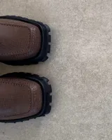 Botín Chelsea de cuero marrón con elástico lateral, punta cuadrada y suela track.