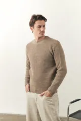 Sweater marrón claro de lana fina, tejido en punto fantasía, con cuello redondo y terminaciones elásticas en puños y ruedo. Hecho en Uruguay.